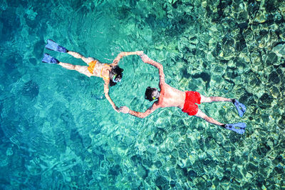 High angle view of friends snorkeling in sea