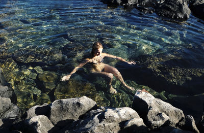 High angle view of shirtless man swimming in sea