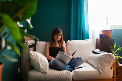 Young woman sitting on sofa