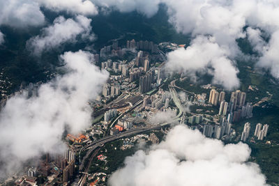 Aerial view of buildings in city against cloudy sky