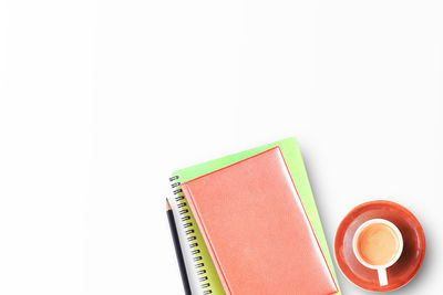 Coffee cup and book against white background