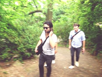 Woman standing on tree trunk in forest