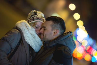 Smiling young couple standing at night during winter