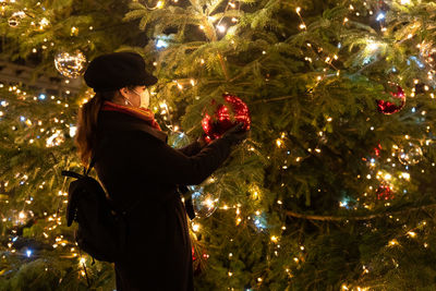 Man standing in illuminated christmas tree