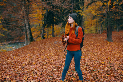 Full length of a woman with autumn trees