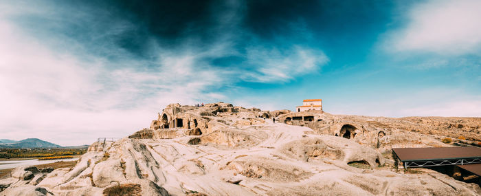 Rock formations on landscape against cloudy sky