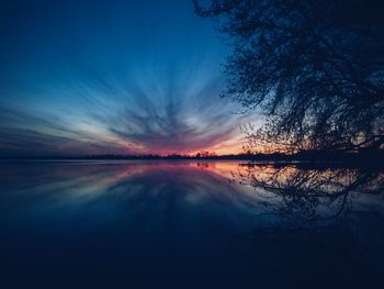 Scenic view of lake against sky at sunset