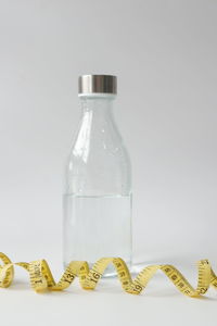 Close-up of glass bottle on table against white background