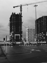 Construction site by buildings against sky in city