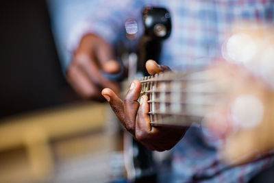 Midsection of man playing guitar