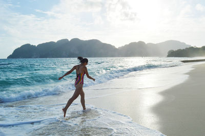 Full length of man standing on beach against sky