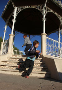 Full length of boy on staircase against sky