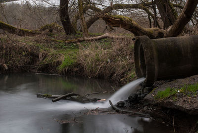 Water falling from pipe in river