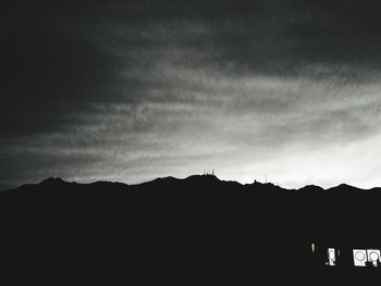 Silhouette of building against cloudy sky