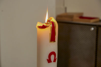 Close-up of red lit candles on wall
