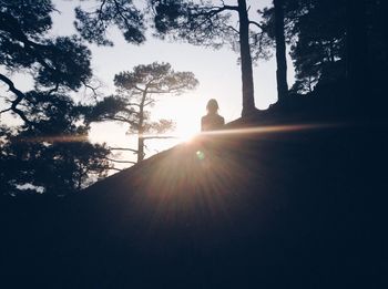 Silhouette man in forest against sky