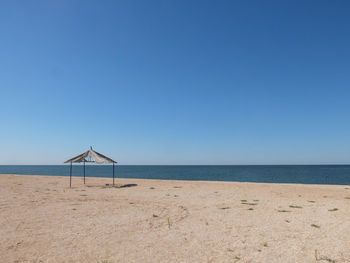 Minimalistic landscape of sandy coastline with old gazebo or pavilion
