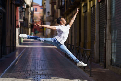 Full length of woman jumping on street