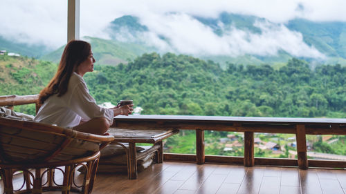 Side view of woman sitting on bench