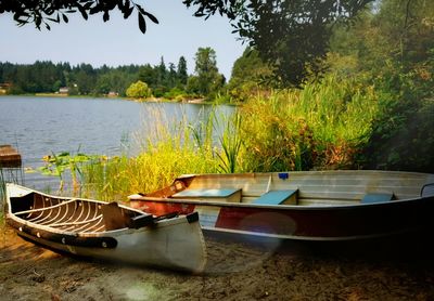 Boats moored in lake against sky