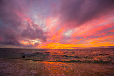 Scenic view of sea against dramatic sky during sunset