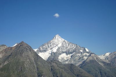 Low angle view of mountains against blue sky