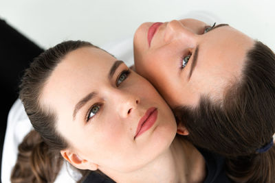 Two beautiful women twin sisters close-up face portrait