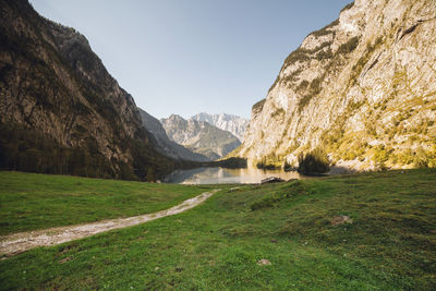 Scenic view of land and mountains against clear sky