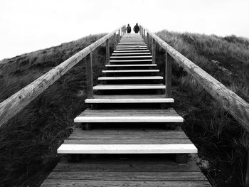 Low angle view of people on steps against sky