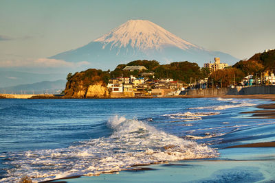 Scenic view of sea and mountains against sky