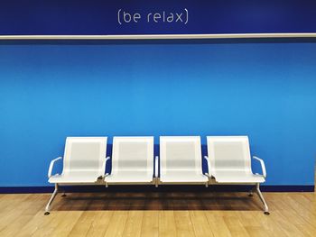 Empty chairs and tables against blue sky