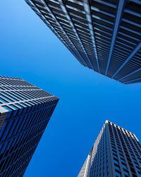 Low angle view of modern buildings against clear blue sky