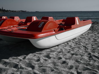 Boats moored on beach against sky