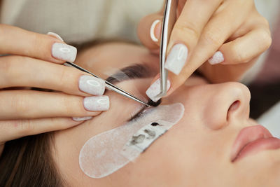 Midsection of woman applying nail polish