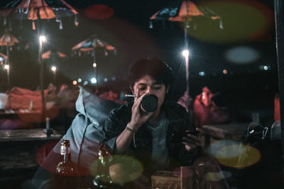 Portrait of man drinking glass in restaurant