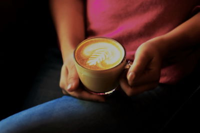 Midsection of woman holding coffee cup