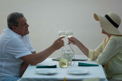 Rear view of man and woman sitting at table