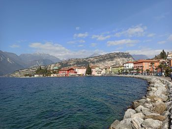 Scenic view of sea by town against sky