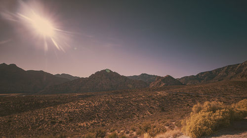 Scenic view of mountains against bright sun