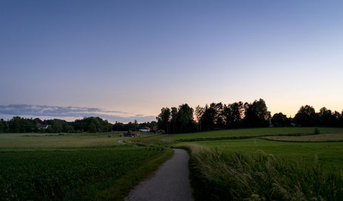 Scenic view of field against clear sky during sunset