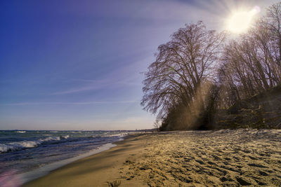 Scenic view of beach against sky and sun