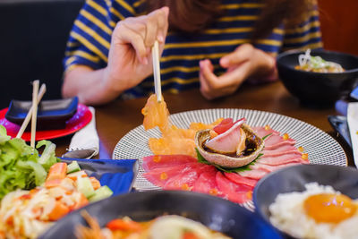 Midsection of man preparing food in plate