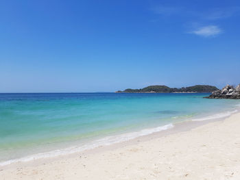 Scenic view of beach against clear blue sky