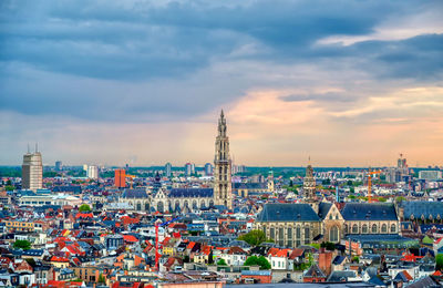 High angle view of city buildings against cloudy sky