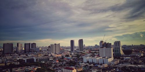 Buildings in city against cloudy sky