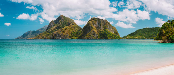 Panoramic view of sea and mountains against sky