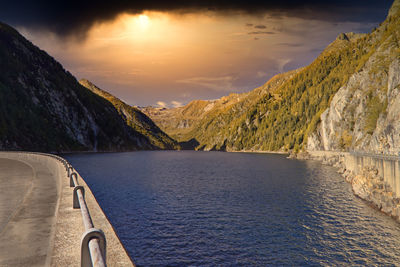 Scenic view of lake by mountains against sky