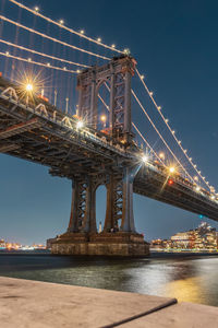 Low angle view of bridge over river at night