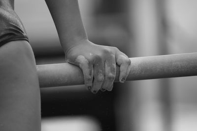 Cropped image of gymnast holding horizontal bar