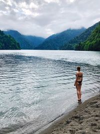 Seductive woman wearing bikini while standing on shore at beach